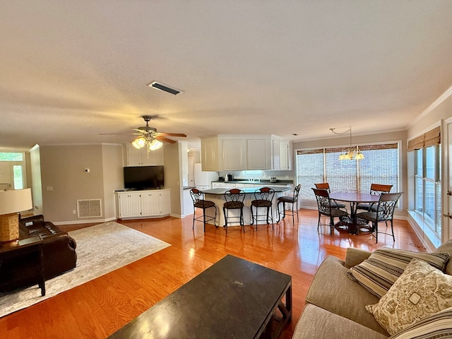 683 B Calhoun Dr, Abbeville, AL 36310 - living room featuring crown molding, light wood-style flooring, healthy amount of natural light, and a ceiling fan