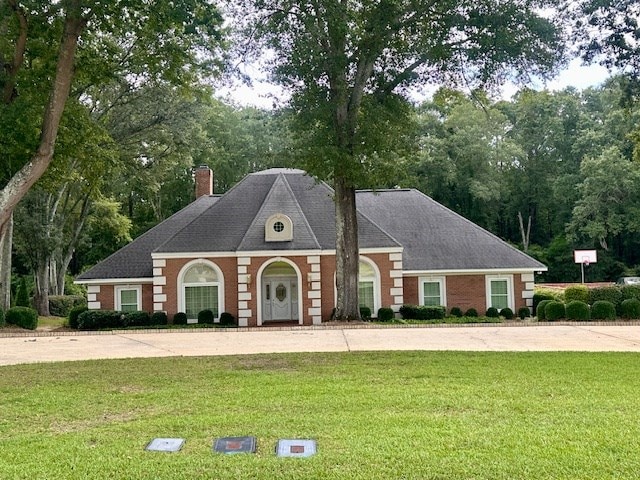 6 Woodmere Dr, Dothan, AL 36305 - view of front of house featuring a chimney, a front lawn, concrete driveway, and view of wooded area