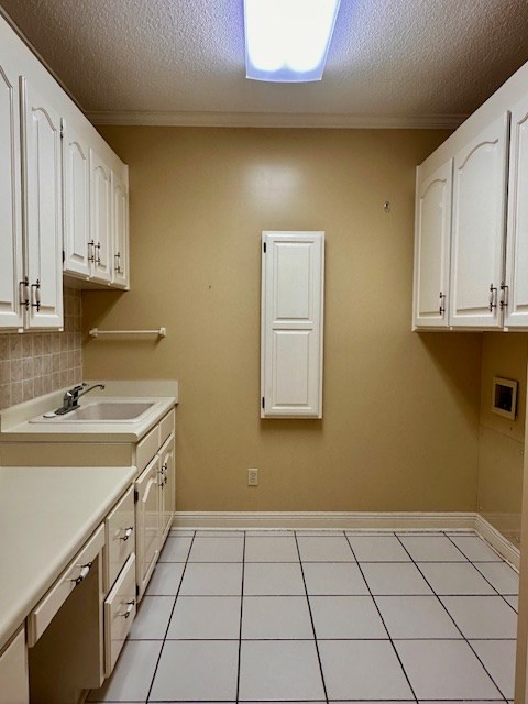 6 Woodmere Dr, Dothan, AL 36305 - laundry area featuring cabinet space, a textured ceiling, light tile patterned flooring, washer hookup, and ornamental molding