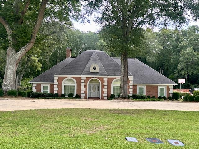 6 Woodmere Dr, Dothan, AL 36305 - view of front facade with a chimney, a front yard, concrete driveway, and view of scattered trees