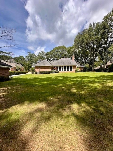 6 Woodmere Dr, Dothan, AL 36305 - back of property featuring a lawn and a chimney