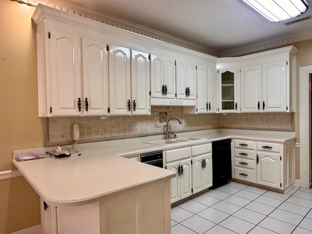 6 Woodmere Dr, Dothan, AL 36305 - kitchen with a peninsula, decorative backsplash, light countertops, white cabinets, and crown molding