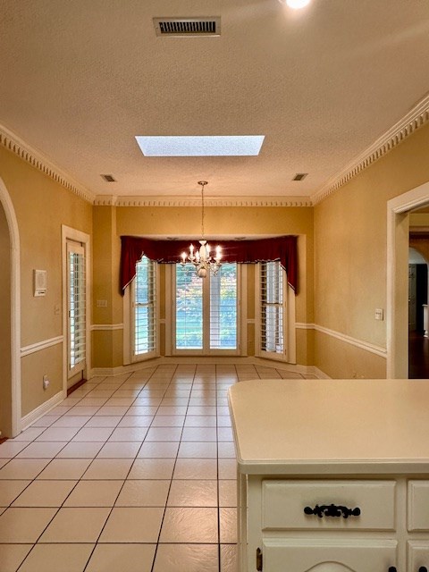 6 Woodmere Dr, Dothan, AL 36305 - kitchen with a skylight, a chandelier, arched walkways, a textured ceiling, and white cabinets