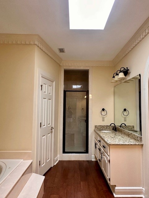 6 Woodmere Dr, Dothan, AL 36305 - full bathroom with a stall shower, vanity, wood finished floors, a bath, and a skylight
