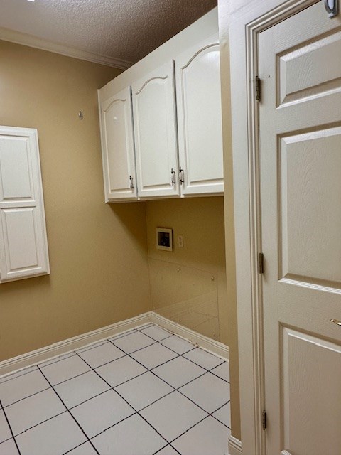 6 Woodmere Dr, Dothan, AL 36305 - laundry room featuring cabinet space, hookup for a washing machine, a textured ceiling, ornamental molding, and light tile patterned floors