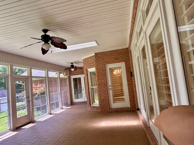6 Woodmere Dr, Dothan, AL 36305 - unfurnished sunroom featuring brick flooring, a ceiling fan, brick wall, and plenty of natural light