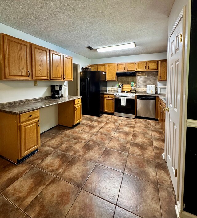 109 Pinehurst Dr, Ashford, AL 36312 - kitchen with stainless steel appliances, brown cabinets, under cabinet range hood, a textured ceiling, and built in desk