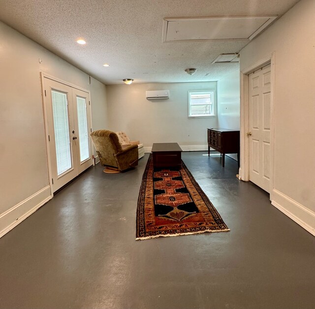 109 Pinehurst Dr, Ashford, AL 36312 - hallway featuring finished concrete floors, attic access, a wall mounted AC, a textured ceiling, and french doors