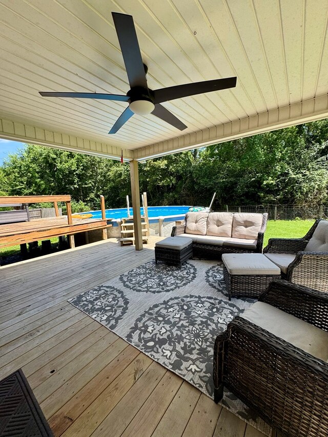 109 Pinehurst Dr, Ashford, AL 36312 - wooden deck with an outdoor living space, an outdoor pool, a fenced backyard, a ceiling fan, and view of wooded area