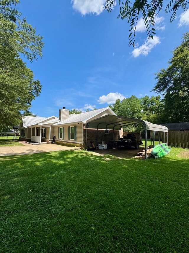 109 Pinehurst Dr, Ashford, AL 36312 - back of property featuring a chimney, a carport, and a metal roof