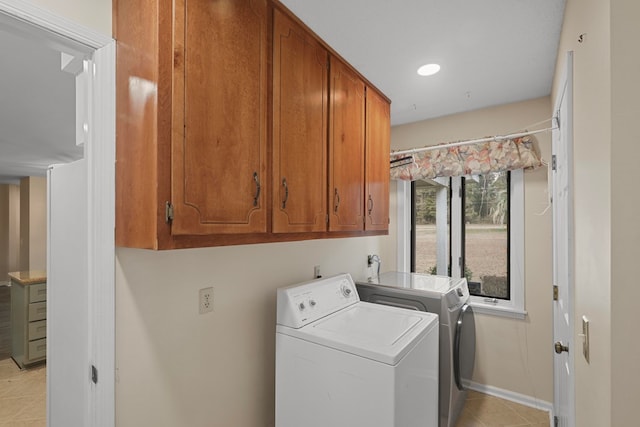 laundry area with light tile patterned floors, washer and clothes dryer, and cabinets