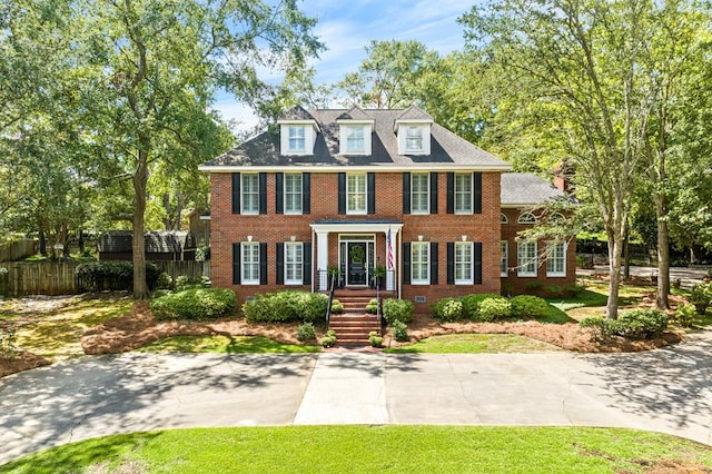 colonial inspired home with crawl space, brick siding, and fence