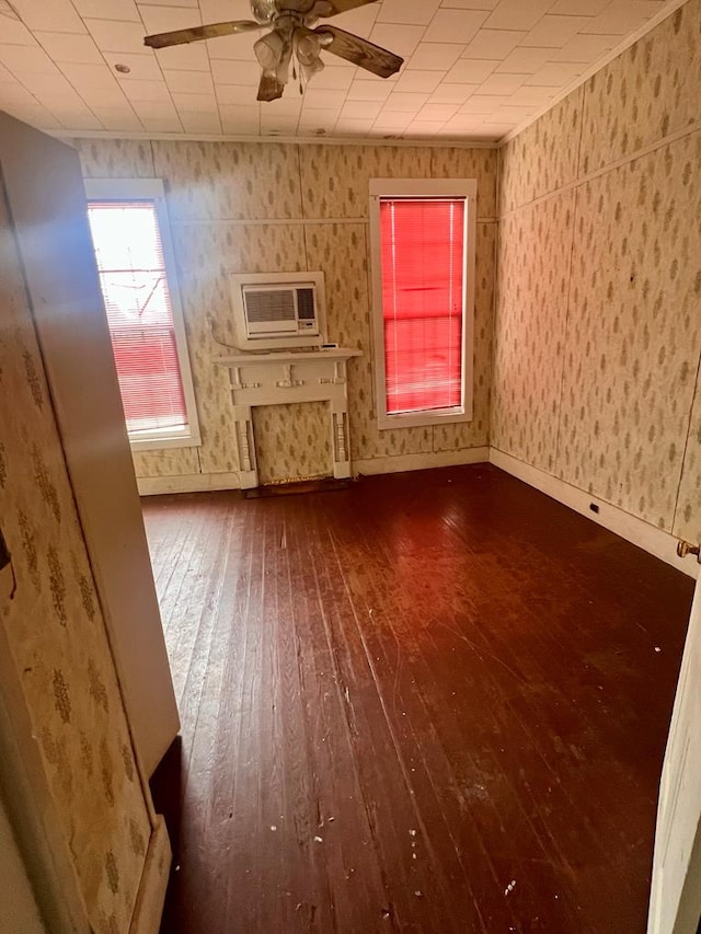 unfurnished living room with hardwood / wood-style floors, a wall mounted AC, and ceiling fan