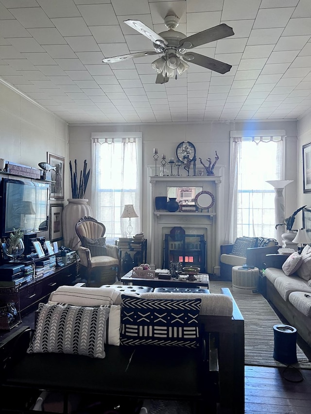 living room featuring a ceiling fan, a fireplace, and wood finished floors