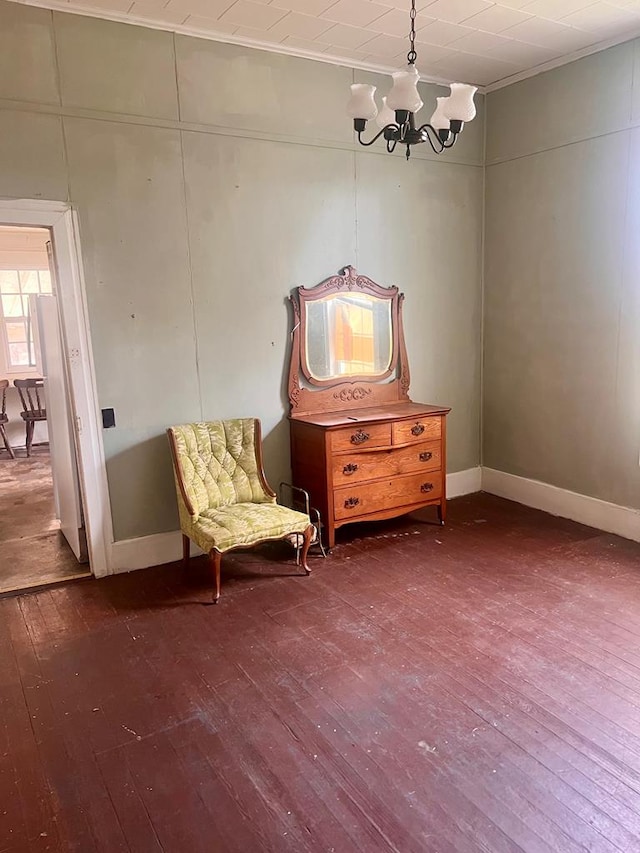 unfurnished room with a notable chandelier, baseboards, and dark wood finished floors