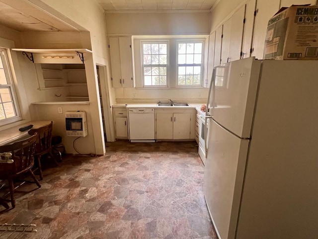 kitchen with light countertops, a healthy amount of sunlight, white appliances, a sink, and heating unit