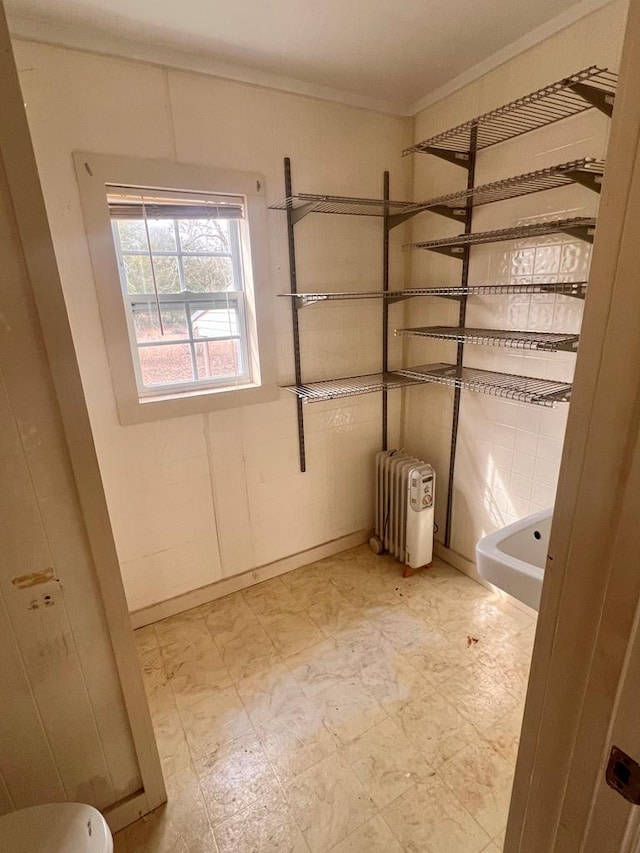 bathroom with tile patterned floors, crown molding, and radiator heating unit