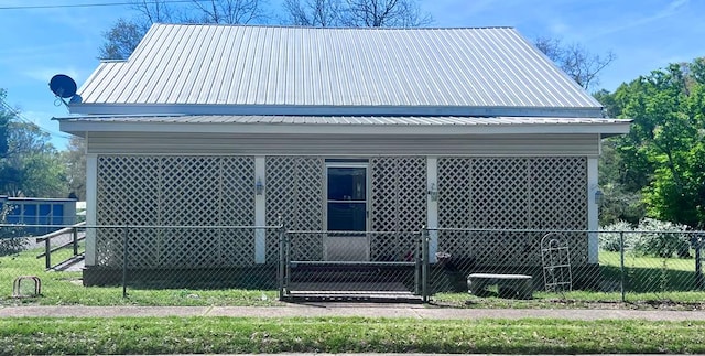 view of side of home with metal roof and fence