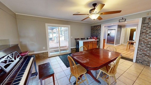 dining area with ceiling fan, light tile patterned flooring, brick wall, and ornamental molding