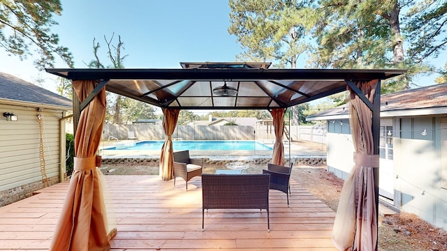 wooden terrace featuring a gazebo and a fenced in pool