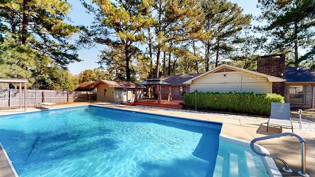 view of pool with a gazebo, a wooden deck, and a diving board