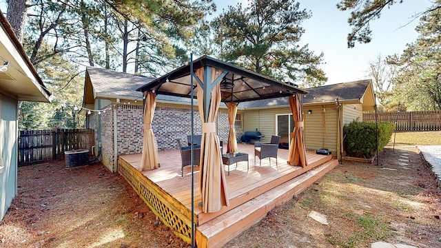 wooden deck featuring outdoor lounge area, a gazebo, and central air condition unit