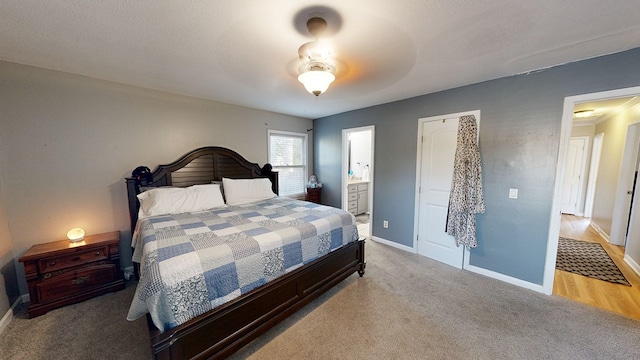 carpeted bedroom with ensuite bathroom and ceiling fan