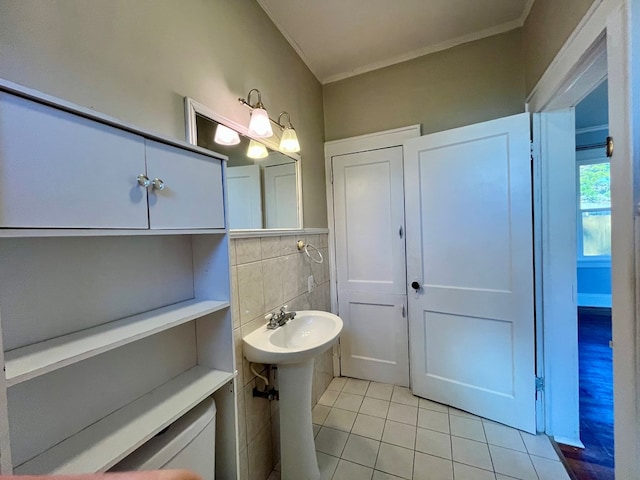 bathroom with sink, tile patterned flooring, tile walls, and ornamental molding