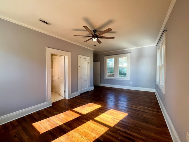 unfurnished bedroom featuring ceiling fan, crown molding, dark wood-type flooring, and connected bathroom