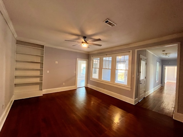 unfurnished living room with built in shelves, crown molding, dark hardwood / wood-style flooring, and ceiling fan