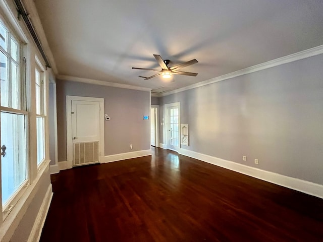 unfurnished room with a healthy amount of sunlight, ornamental molding, and dark wood-type flooring