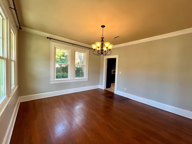 empty room featuring a notable chandelier, ornamental molding, and dark wood-type flooring