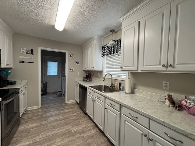 kitchen with white cabinets, a sink, light wood-type flooring, a textured ceiling, and appliances with stainless steel finishes
