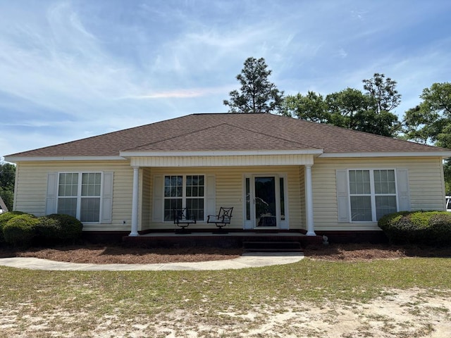 back of house with a shingled roof and covered porch