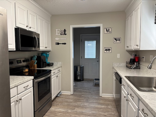 kitchen featuring white cabinets, stainless steel appliances, and light wood-style floors