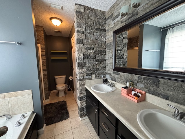 bathroom featuring tile patterned flooring, a sink, and a textured ceiling