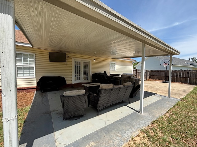 view of patio / terrace featuring fence, grilling area, an outdoor kitchen, and french doors