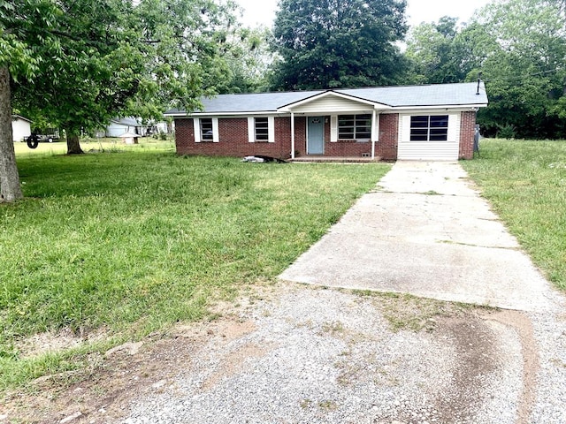 ranch-style home featuring a front yard, driveway, covered porch, and brick siding
