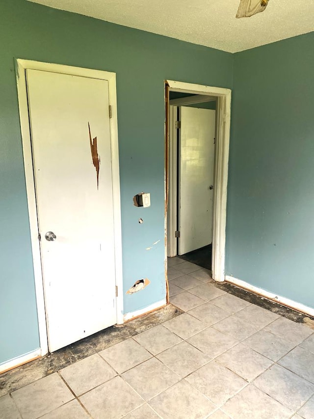 unfurnished bedroom with baseboards and light tile patterned floors