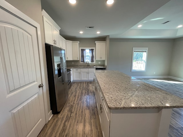 kitchen featuring white cabinets, a center island, stainless steel appliances, and dark hardwood / wood-style floors