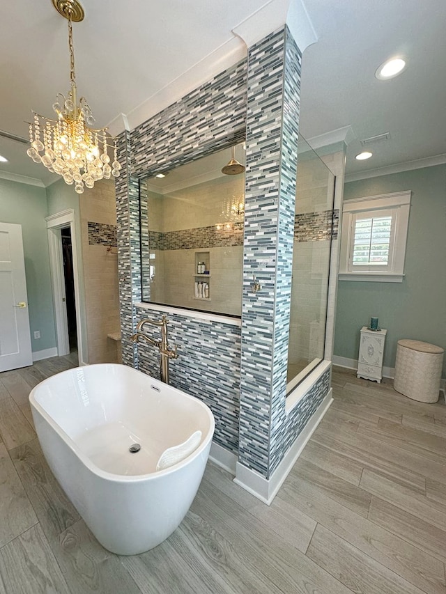 bathroom featuring crown molding, plus walk in shower, a notable chandelier, and hardwood / wood-style flooring