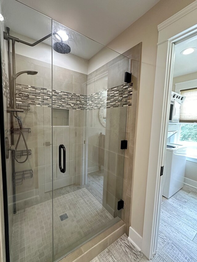 bathroom with wood-type flooring and a shower with shower door