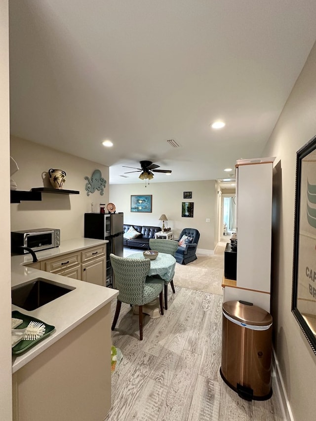 interior space featuring ceiling fan, light wood-type flooring, and sink