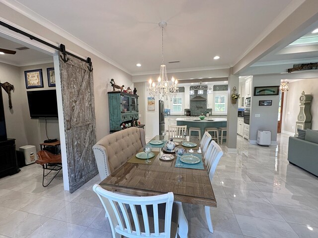 dining room featuring a chandelier, a barn door, and crown molding