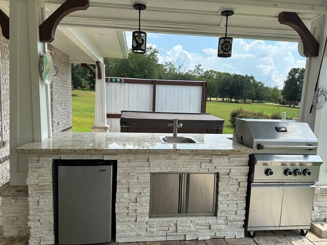 view of patio featuring an outdoor kitchen, area for grilling, and sink