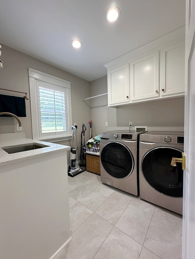 laundry room featuring cabinets, separate washer and dryer, and sink