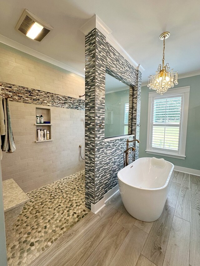 bathroom with hardwood / wood-style floors, ornamental molding, shower with separate bathtub, and a chandelier