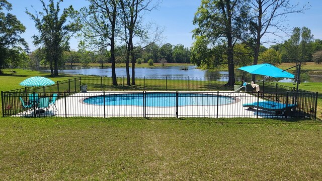 view of pool with a water view, a patio area, and a lawn