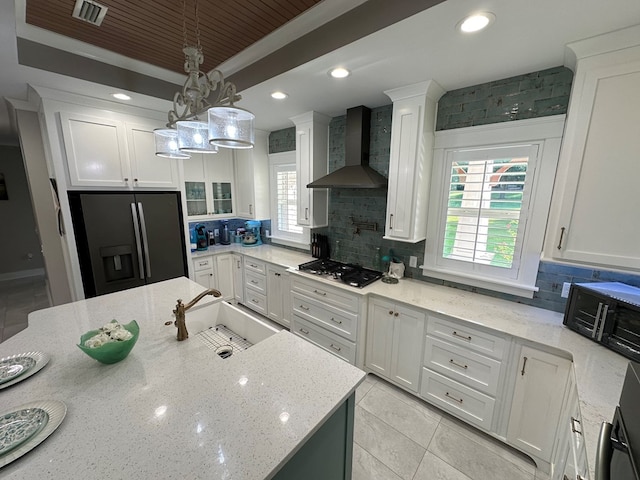 kitchen with backsplash, sink, wall chimney range hood, and appliances with stainless steel finishes