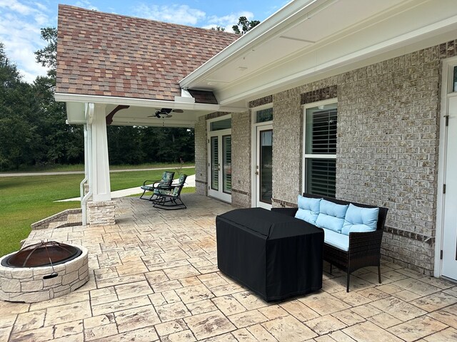 view of patio with ceiling fan and an outdoor fire pit